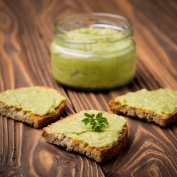 48436318 - natural homemade diy vegan very healthy green paste made of avocado, millet gruel, chilli, garlic and parsley on bread and wooden table