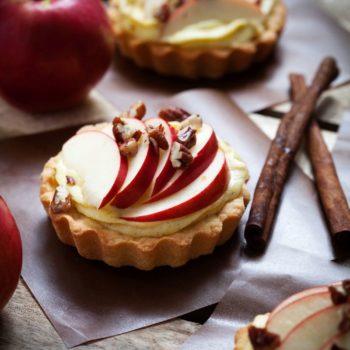 Tartlets with apple slices, cream and pecan filling